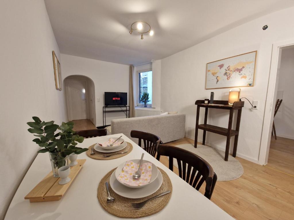 a dining room and living room with a table and chairs at Ferienwohnung in Krefeld in Krefeld
