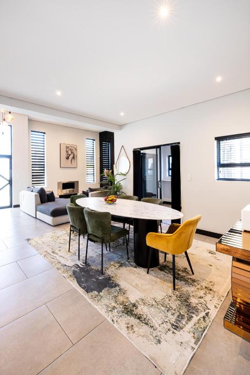 a living room with a table and chairs at Phoenix Home in Cape Town