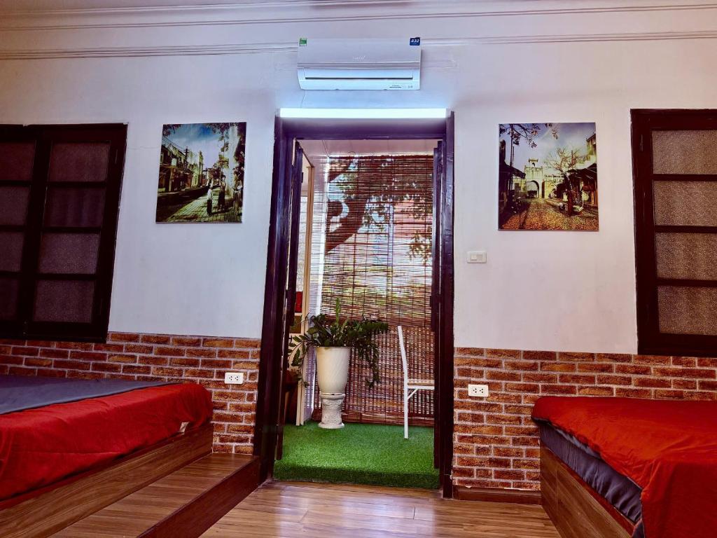 a room with two beds and a door with a window at House with balcony,K Home 1,Old Quarter,3 mins to Hoankiem Lake in Hanoi