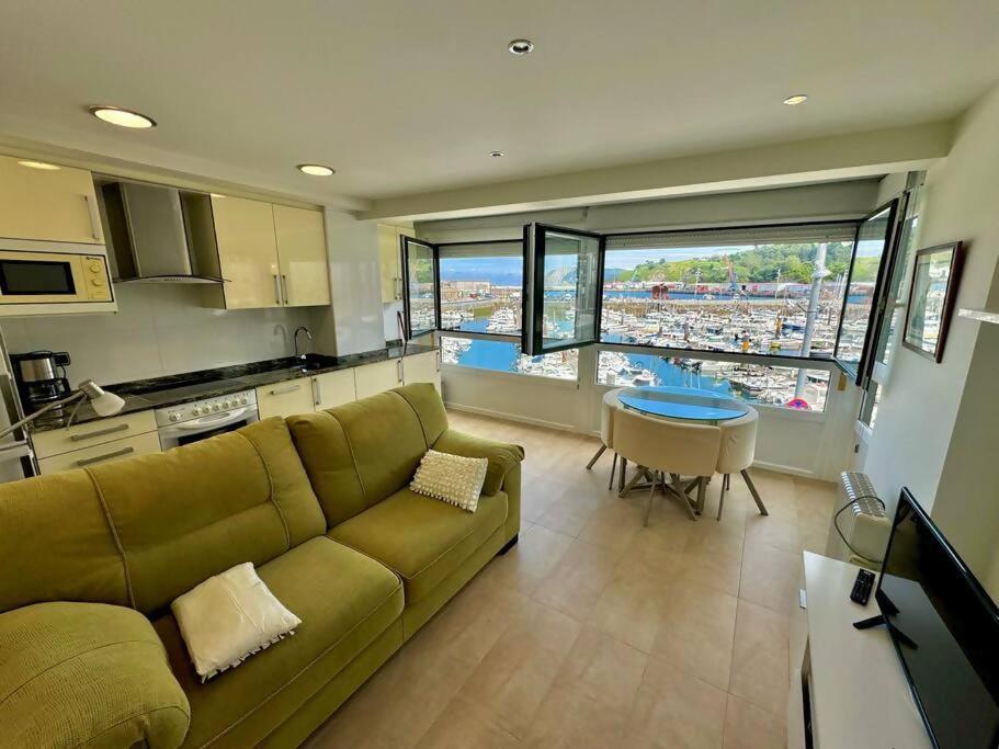 a living room with a couch and a table and a kitchen at Kai begi, vistas maravillosas al puerto in Bermeo