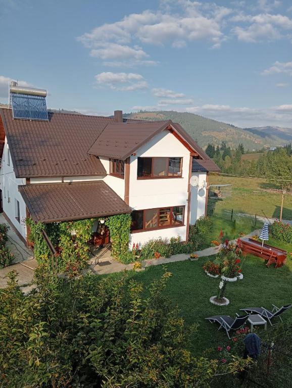 a white house with a brown roof at Casa Vasy in Vatra Dornei
