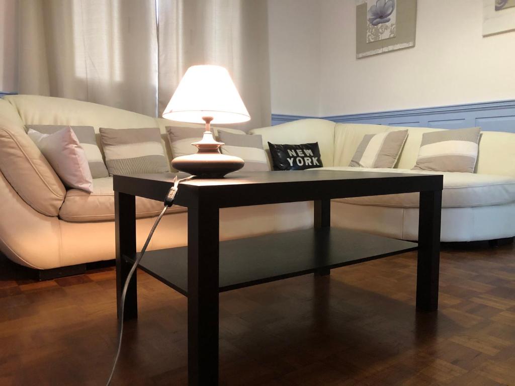 - un salon avec un canapé et une table avec une lampe dans l'établissement Bel appartement centre Saint Brieuc a pied, à Saint-Brieuc