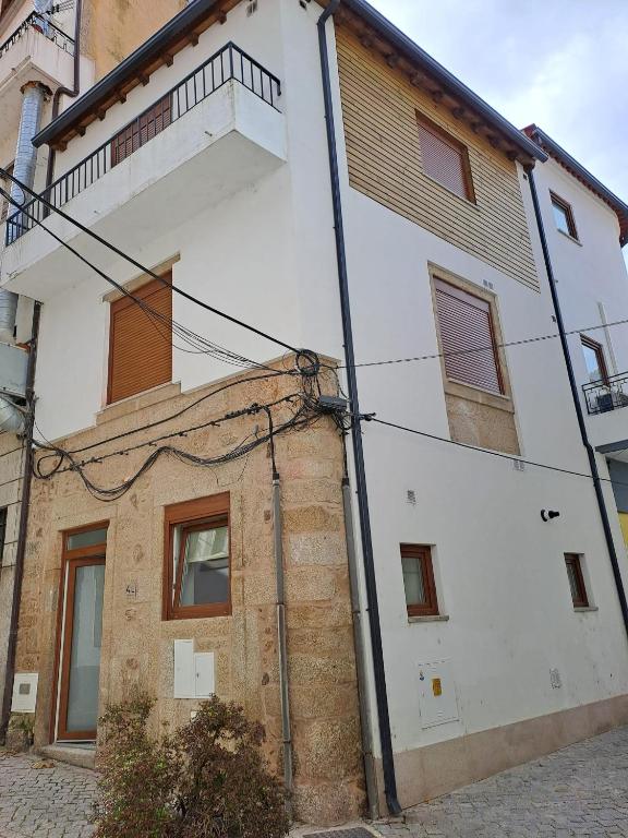 a white building with a balcony on top of it at Casa da Travessa in Seia