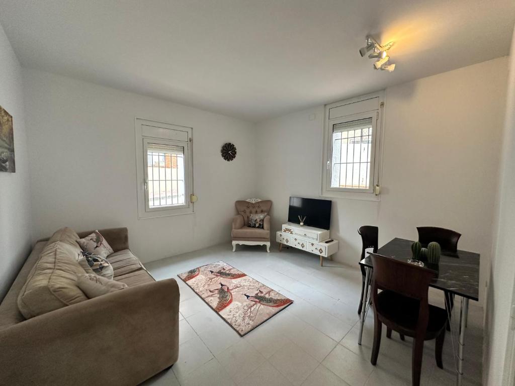 a living room with a couch and a table at Relax Holiday Home in Vallromanas
