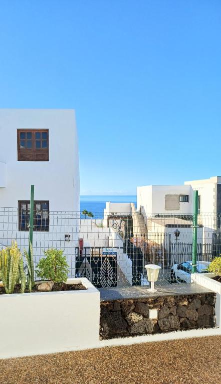 a view of a building with the ocean in the background at Bright & spacious with aircon in Puerto del Carmen
