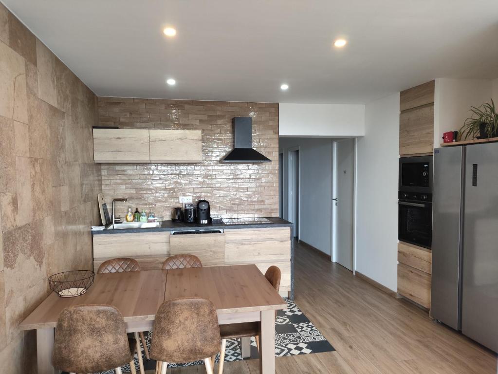 une cuisine avec une table en bois et quelques chaises dans l'établissement 3 Chambres 3 Salles de bain Vue panoramique Lyon, à Lyon