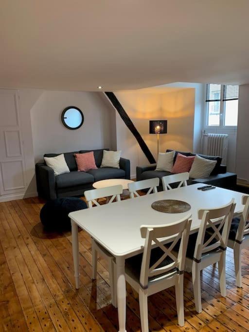 un salon avec une table, des chaises et un canapé dans l'établissement Appartement #4 cœur de ville, au Mans