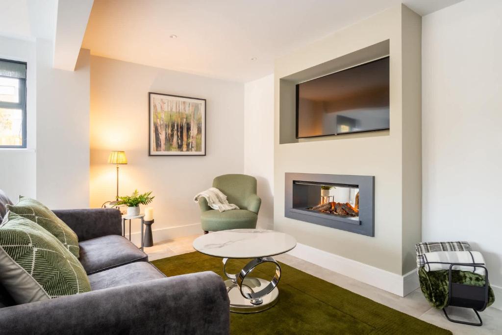 a living room with a couch and a fireplace at The Lodge Private Parking & Garden in Cheltenham