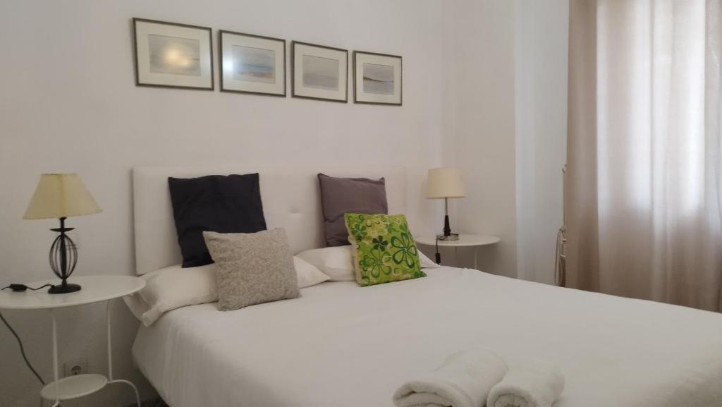 a bedroom with a large white bed with pillows at URBION HOME in Seville