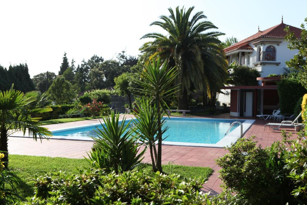 una piscina frente a una casa con palmeras en Quinta de Santo Antonio, en Muro
