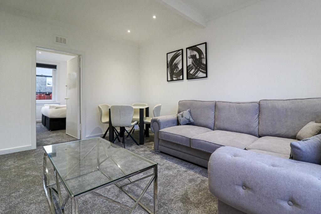 a living room with a couch and a table at Serviced Apartment near Prestwick Airport with Private Parking - Long Stays Available in Prestwick