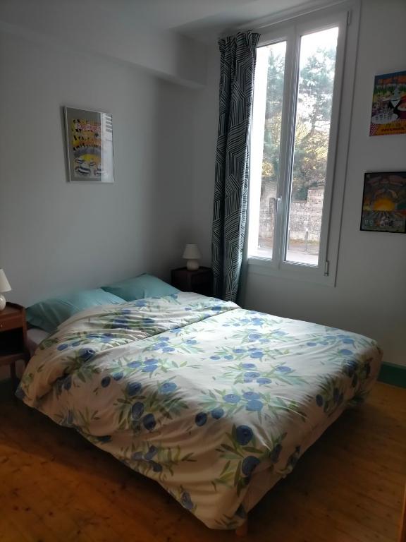 un lit dans une chambre avec une fenêtre dans l'établissement Appartement ancien entièrement rénové plein sud, à Dieppe