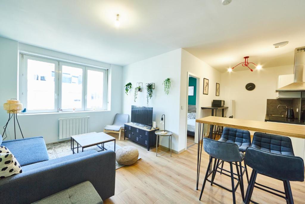 un salon avec un canapé et une cuisine dans l'établissement BE-4D - Appartement F3 pour 1-4 pers au 4ème étage au centre de Mulhouse, à Mulhouse