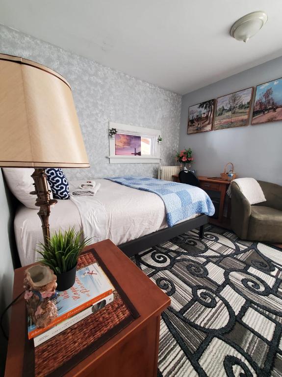 a bedroom with a bed and a table with a lamp at Merj's Guest House in Wolesly in Winnipeg