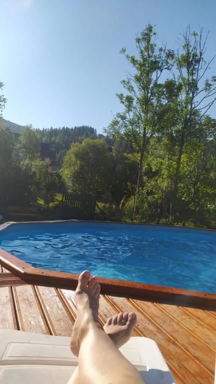 a man laying on a deck next to a swimming pool at Zawojskie Spanie in Zawoja