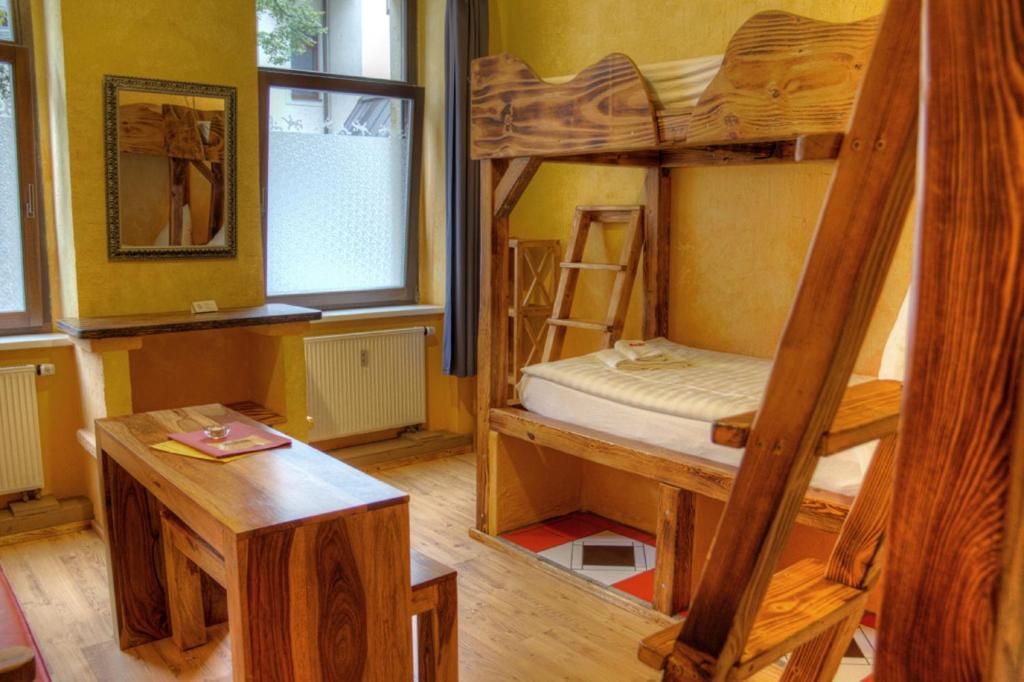 a room with two bunk beds and a table at Gästehaus Mezcalero in Dresden