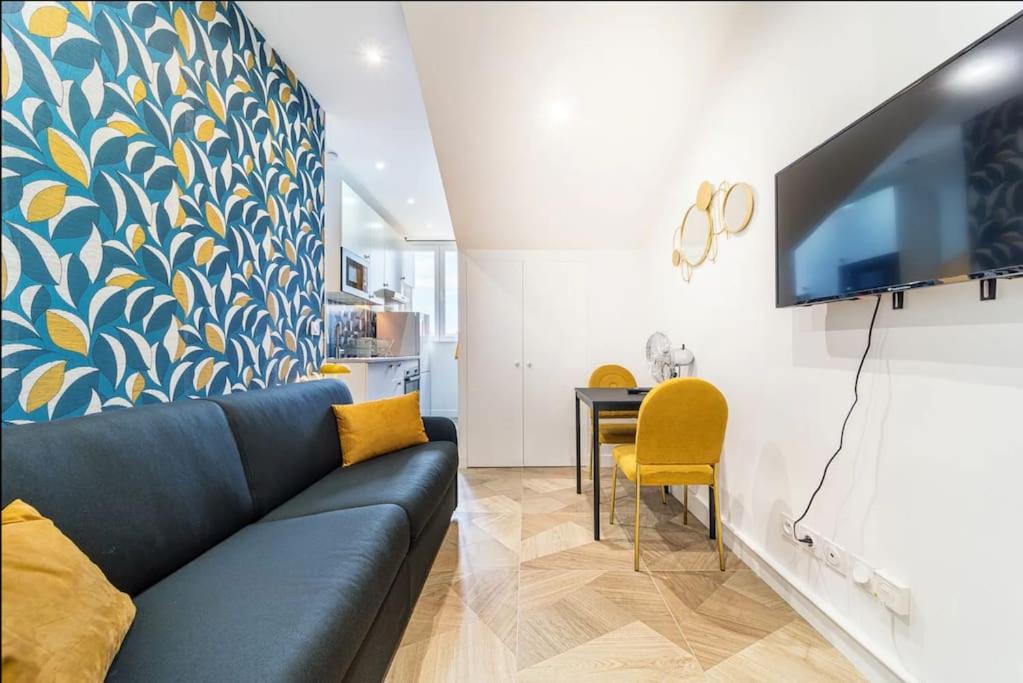 un salon avec un canapé bleu et une table dans l'établissement Magenta, Charmant & Moderne, à Villeurbanne