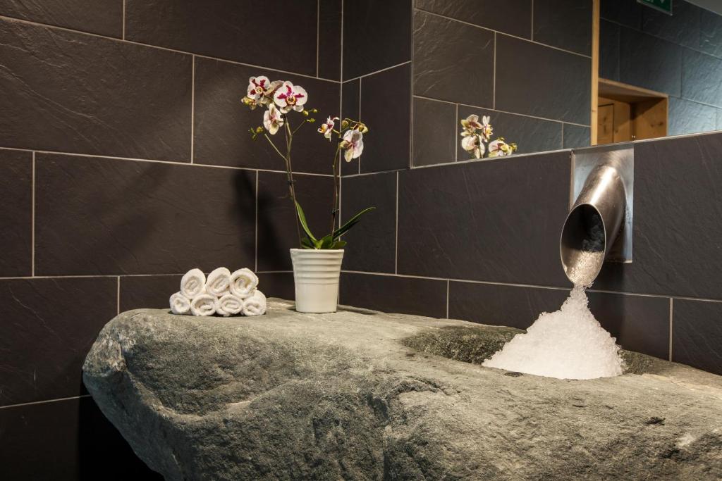 a bathroom with a sink with a vase of flowers at Hôtel National Resort & Spa in Champéry