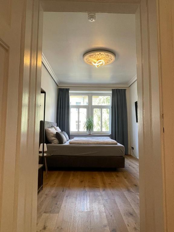 Hotel Soul-Apartment Balkon PrivatParkplatz 2 Boxspringbetten 55Zoll TV WLAN, a bedroom with a bed in front of a window at Soul-Apartment Balkon PrivatParkplatz 2 Boxspringbetten 55Zoll TV WLAN in Leipzig