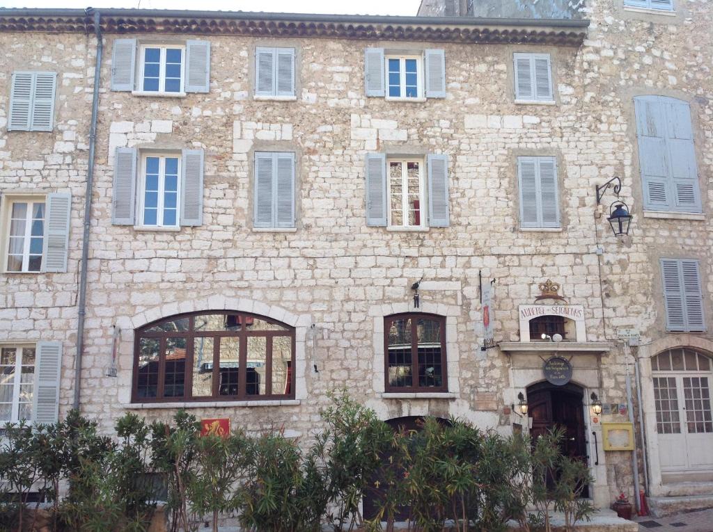 un gran edificio de ladrillo con ventanas blancas en Auberge des Seigneurs en Vence