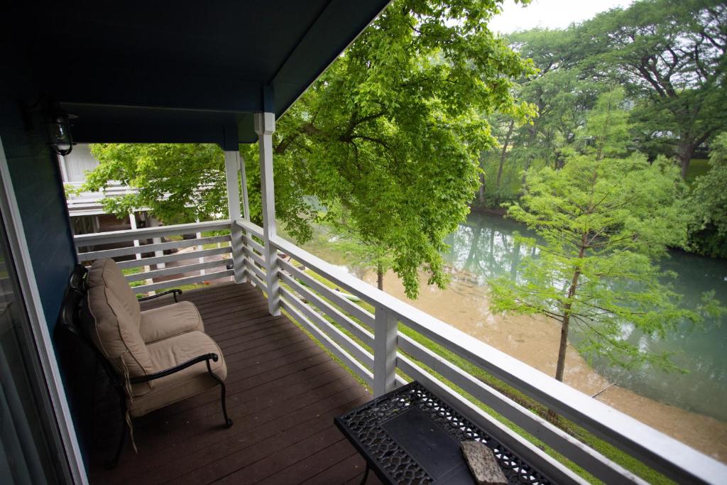 a porch with a chair and a view of a river at Water Haus in Fourth Crossing