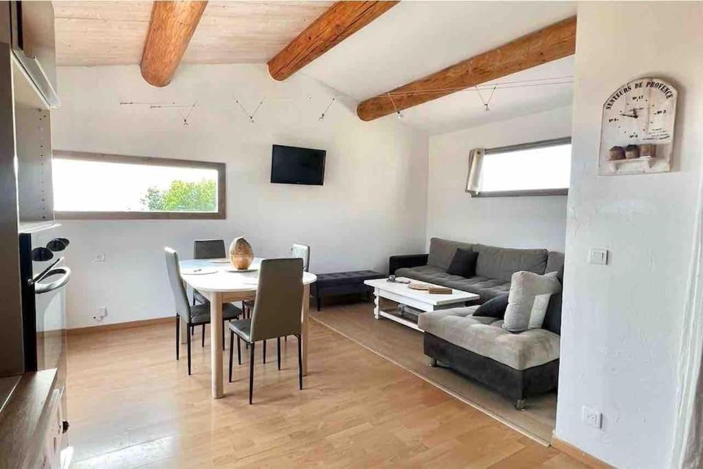 Appartement de 2 à 6 personnes 3 chambres proche Aéroport Marseille Marignane -confortable - et tout équipé في روجناك: غرفة معيشة بها طاولة وأريكة