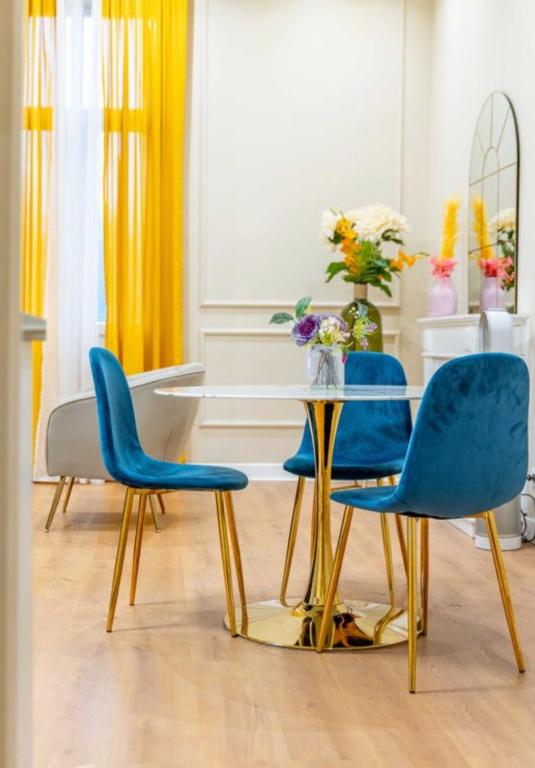 une salle à manger avec des chaises bleues et une table dans l'établissement Appartement de Prestige Le Saphir - 60m2, à Périgueux