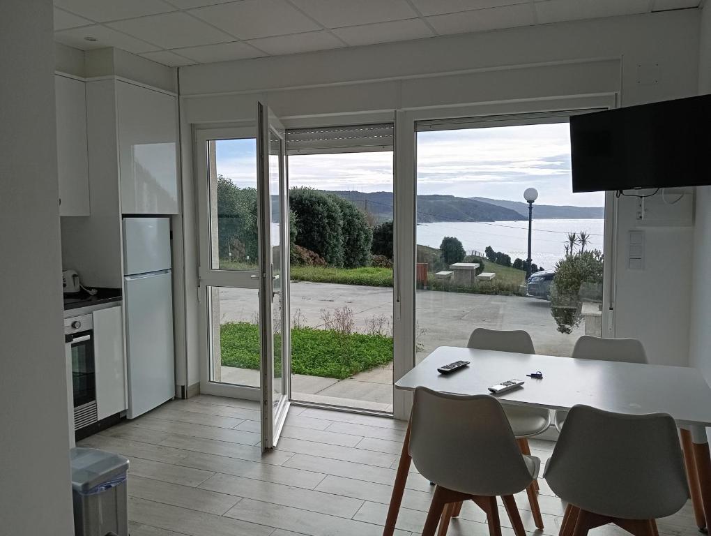 cocina con mesa y sillas y ventana grande en Apartamentos NEMIÑA, en A Coruña
