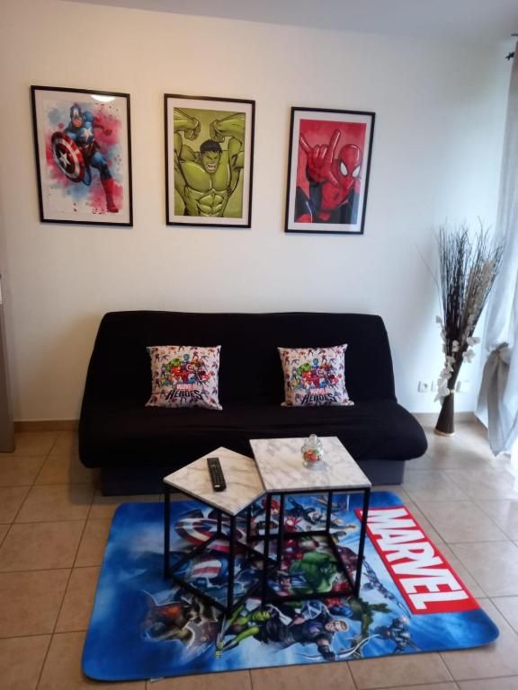 un salon avec un canapé noir et une table dans l'établissement B206 Disneyland Paris AppartementAppartement, à Montévrain