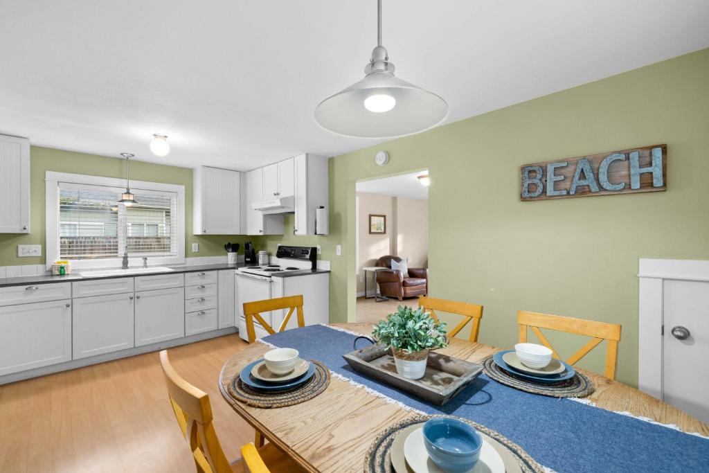 a kitchen and dining room with a table and chairs at Alpine Coast Cottage - Meredith Lodging in Rockaway Beach