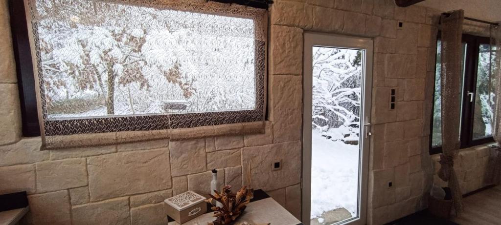 a room with a window and a door with snow at Forest Hide Tiny House in Covasna