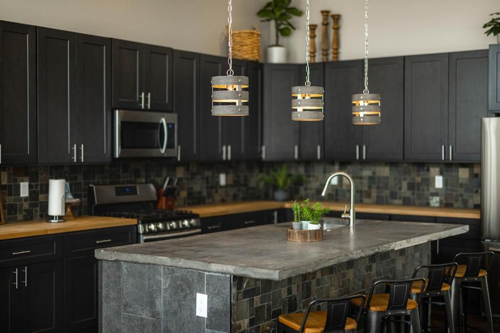 - une cuisine avec des placards noirs et un plan de travail en granit dans l'établissement The Chandler at Sand Hollow Resort, à Hurricane