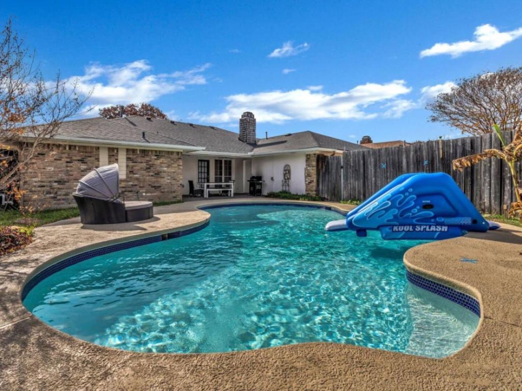 a swimming pool with a slide in front of a house at City Gem 4BR with POOL Sleeps 8 in Plano