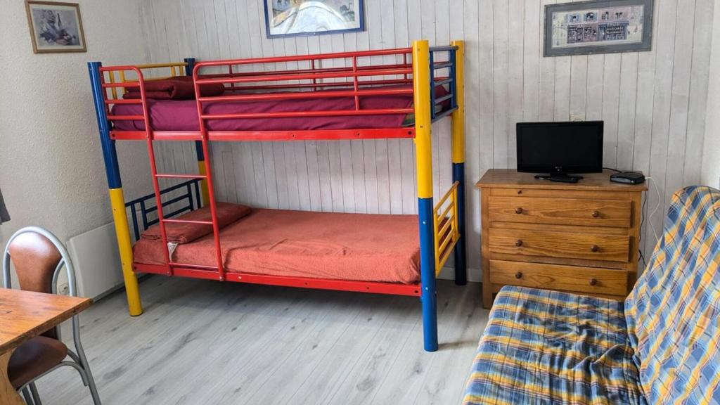 Cette chambre comprend deux lits superposés et un bureau avec une télévision. dans l'établissement Résidence Rond-point-pistes I - Mini studio 19m² 4 pers ROND POINT DES PISTES 1 -N° 122 MAE-7144, à Orcières