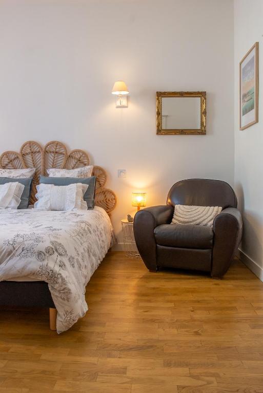 une chambre avec un lit et une chaise dans l'établissement Centre historique de Vitré avec garage, à Vitré