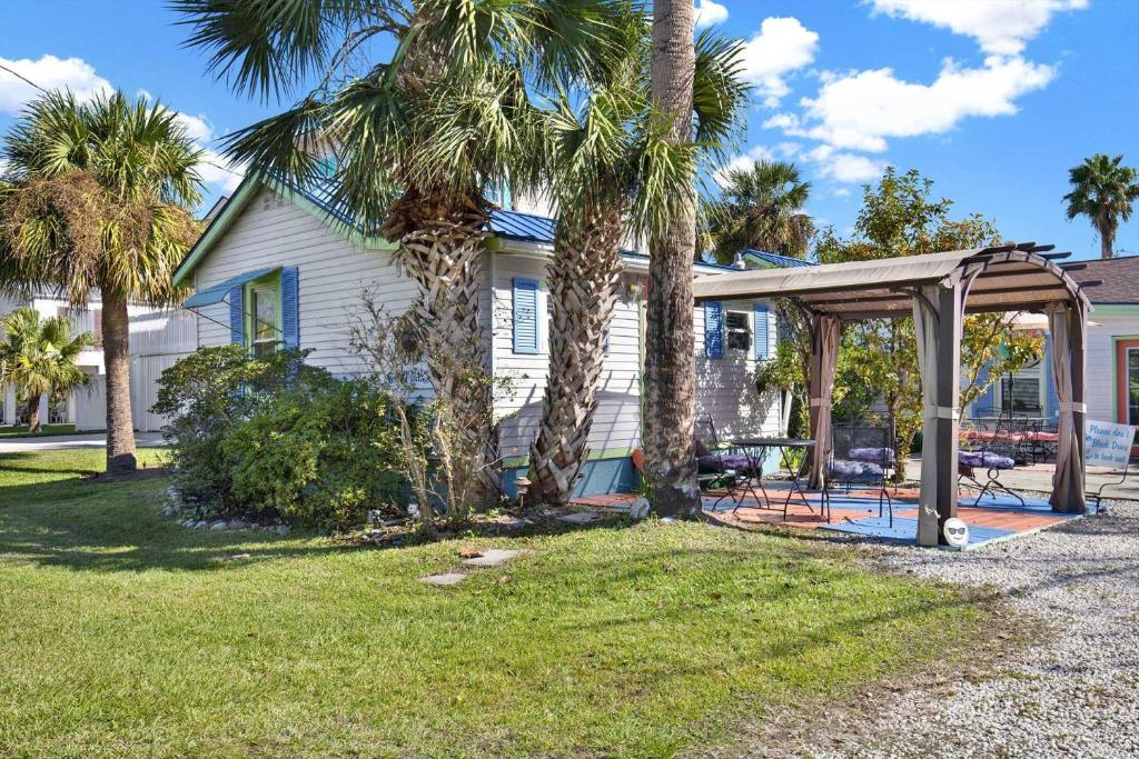 a house with a gazebo and palm trees at Suncatcher Cottage 1508-2nd Avenue A in Tybee Island