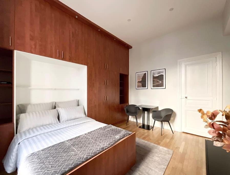 une chambre avec un grand lit et une table dans l'établissement Champs-Élysées 5 étoiles appartement, à Paris