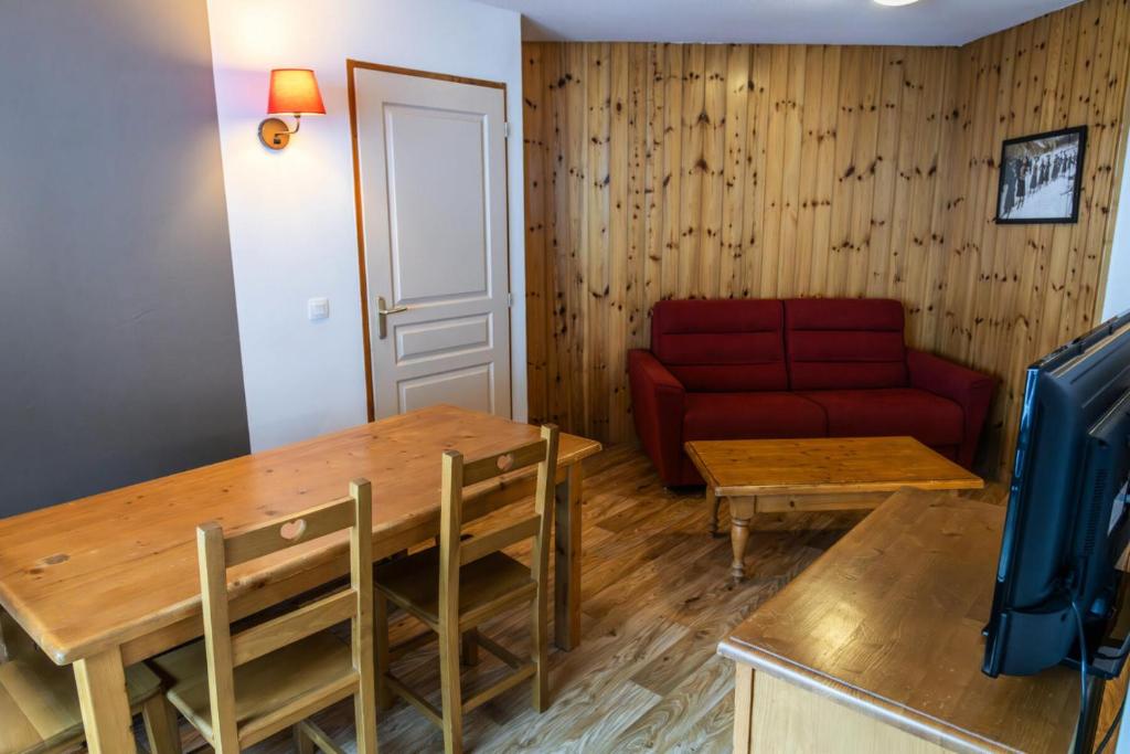 un salon avec un canapé rouge et une table dans l'établissement Résidence Les Hauts De Preclaux - Appartement avec deux chambres et vue pistes MAE-8191, aux Orres