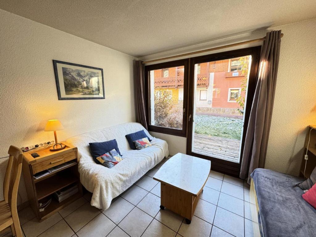 un salon avec un canapé et une grande fenêtre dans l'établissement Chalets Jardin Alpin - Chalet Alpin - 8 personnes MAE-9111, à La Salle Les Alpes