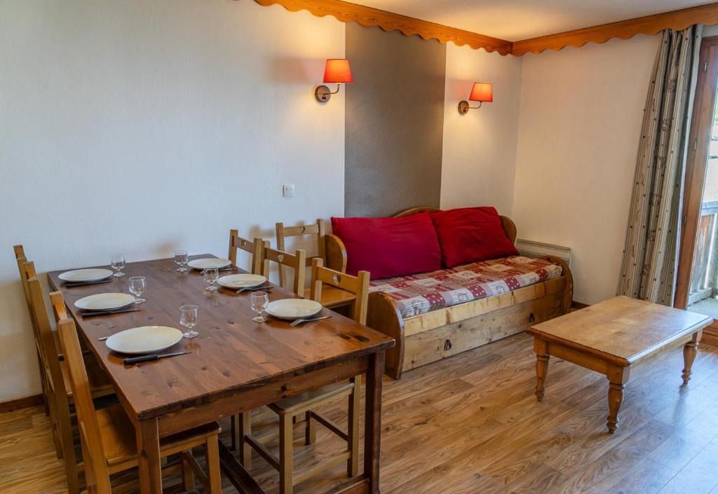 une salle à manger avec une table et un canapé dans l'établissement Résidence Les Hauts De Preclaux - Appartement en duplex au coeur des Orres 1800 MAE-9201, aux Orres