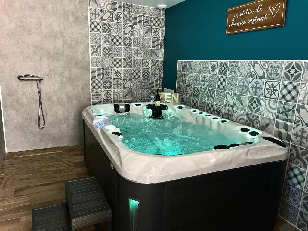 a bathroom with a jacuzzi tub in a room at Gîte jacuzzi à la Cavalerie de Montchaton in Montchaton
