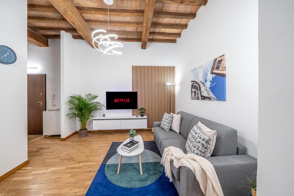 Martin's Home - Large Design Apartment, Fast Wi-Fi, Free Parking, AC in Modena Historic Center في مودينا: غرفة معيشة بها أريكة وجهاز تلفزيون