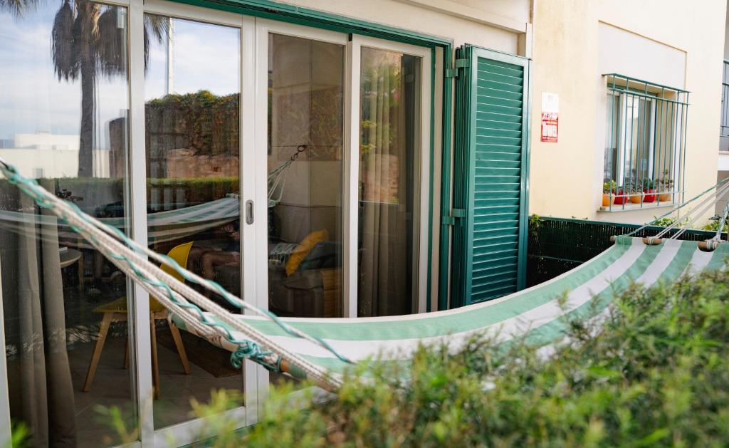 een huis met een groene deur en een hangmat bij Wonderful Apartment in Ferragudo 2Double Beds near Beaches and Golf in Ferragudo