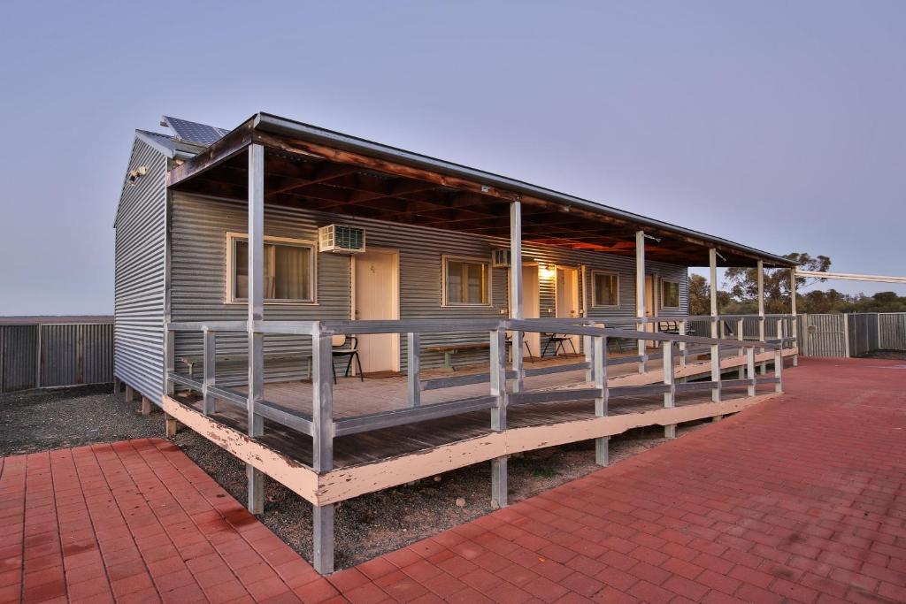 a house with a large deck on a brick driveway at Mungo Shearers' Quarters in Mungo