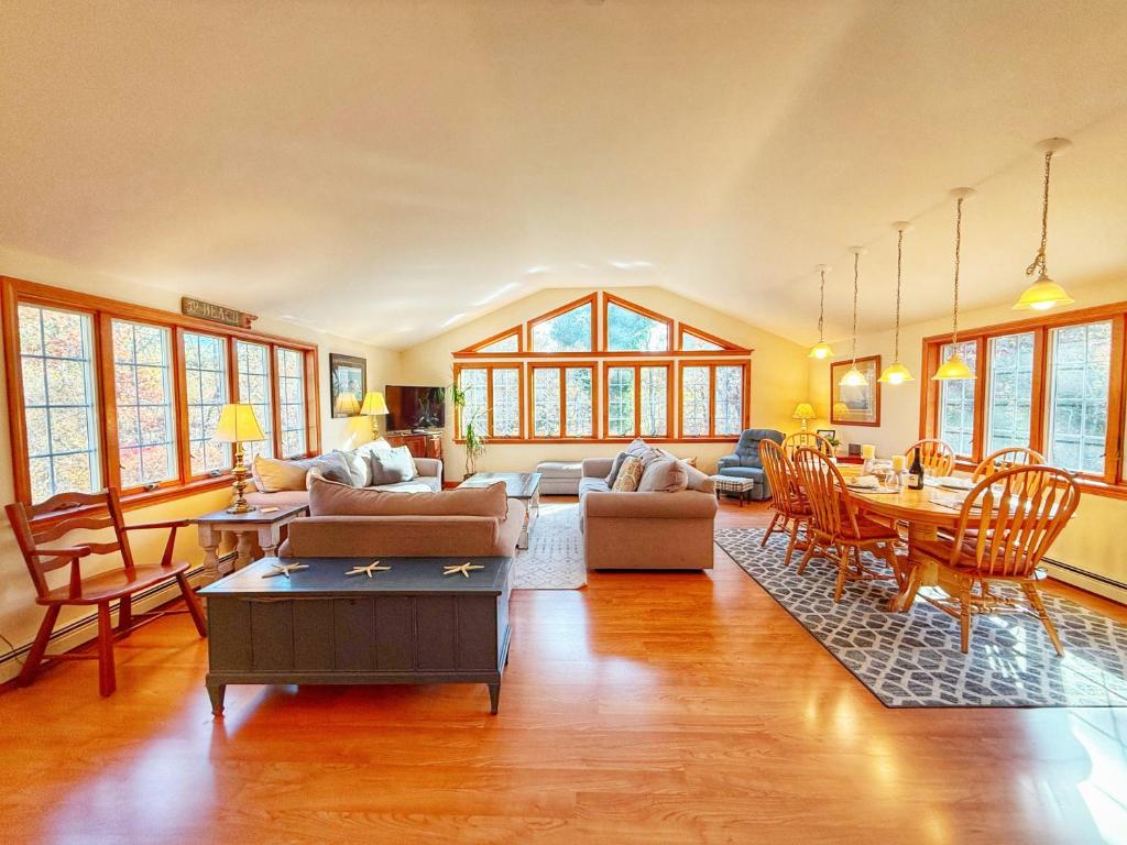 a living room filled with furniture and a table at Tranquil Oasis With Firepit in Harwich