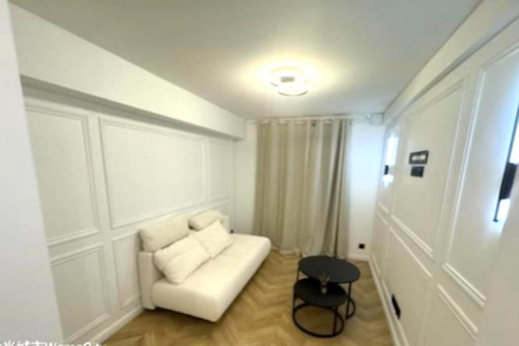 - un salon avec un canapé blanc et un tabouret dans l'établissement Studio Coup de Cœur Ménilmontant, à Paris