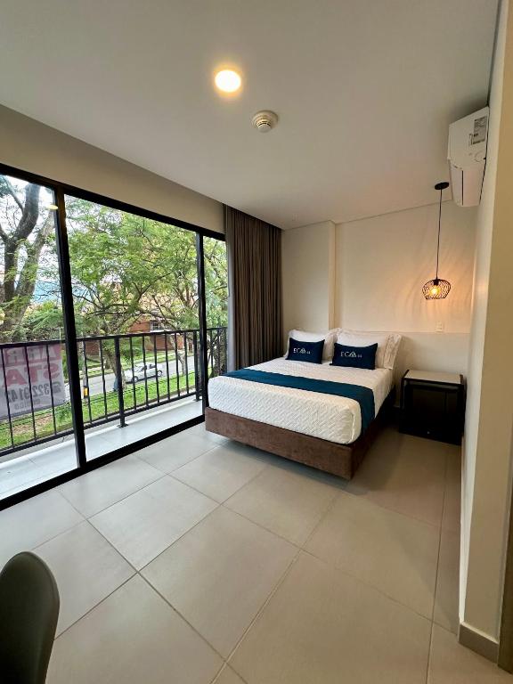 a bedroom with a bed and a large window at Hotel ECO 44 in Medellín