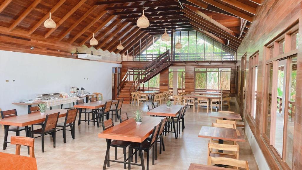 Tantiri River Resort في بويرتو مالدونادو: غرفة طعام مع طاولات وكراسي خشبية