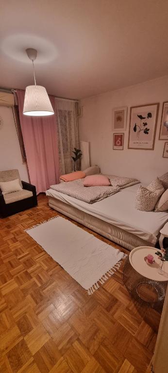a bedroom with two beds and a table at Apartman Kosa in Bežanija