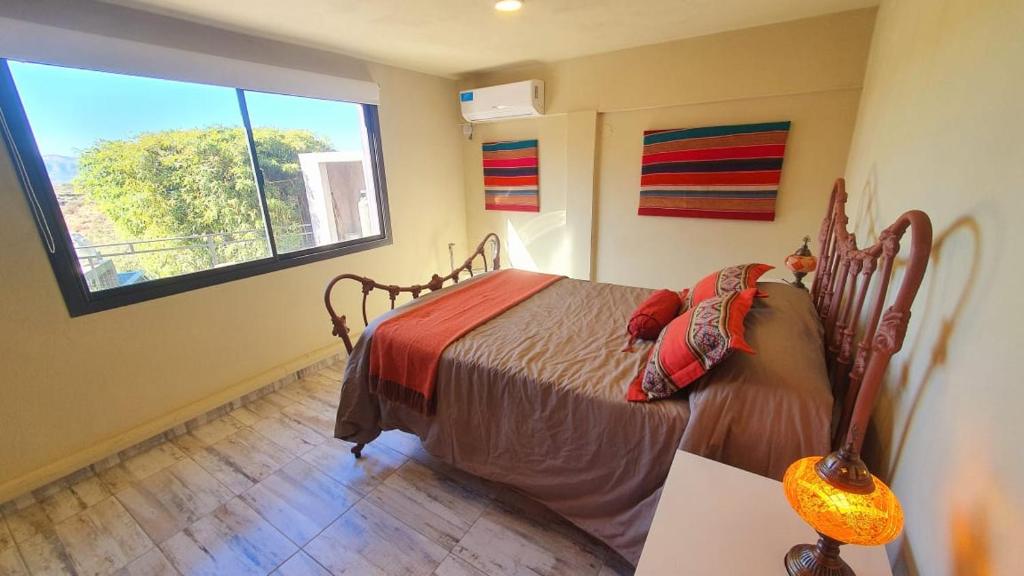 una camera da letto con un letto e una grande finestra di La Moradita Villa Carlos Paz a Villa Carlos Paz